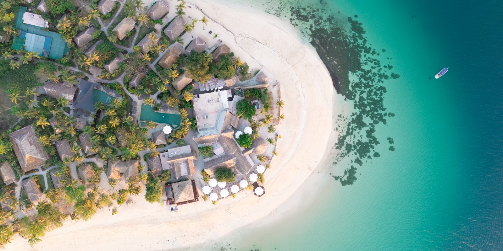 Aerial view of a private tropical island resort surrounded by turquoise water